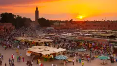 Jamaa el Fna market square at golden hour in Marrakesh, Morocco.