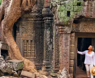 Image of a woman looking up in the ruins of an ancient temple in the rainforest