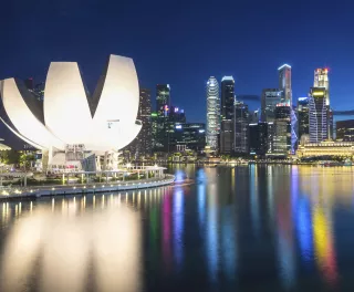 Singapore city skyline with high-rise buildings and lights reflecting on water at night