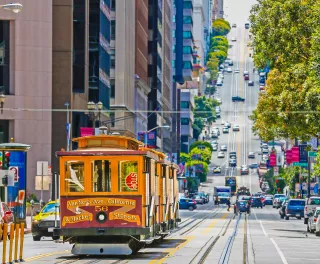 A tram cable car in a busy San Francisco street 