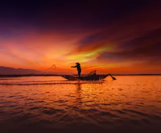 Silhouette of traditional fisherman throwing net fishing inle lake at sunrise time, Myanmar