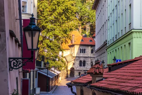 A synagogue at the end of a  shaded street in a historic part of Prague 