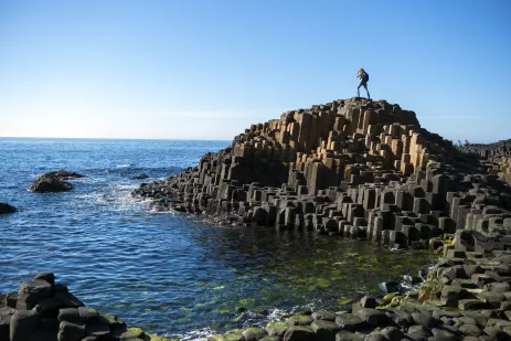 Person standing on the volcanic columns at Giant's Causeway in Northern Ireland