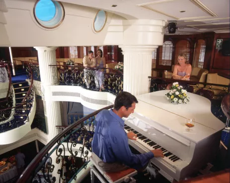 Pianist playing a white grand piano aboard the Royal Clipper ship